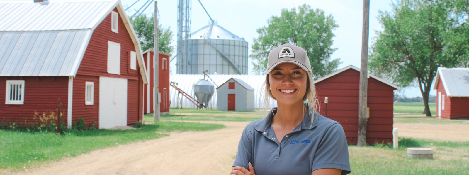Woman standing in front of farm buildings
