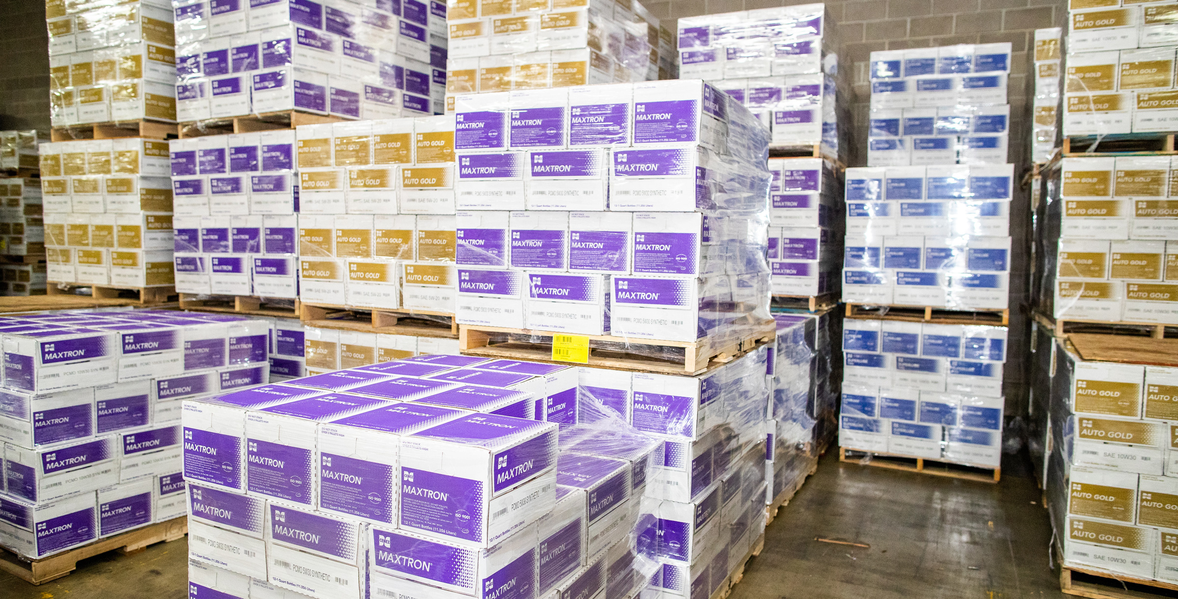 Maxtron and Autogold product boxes sitting on pallets in a warehouse